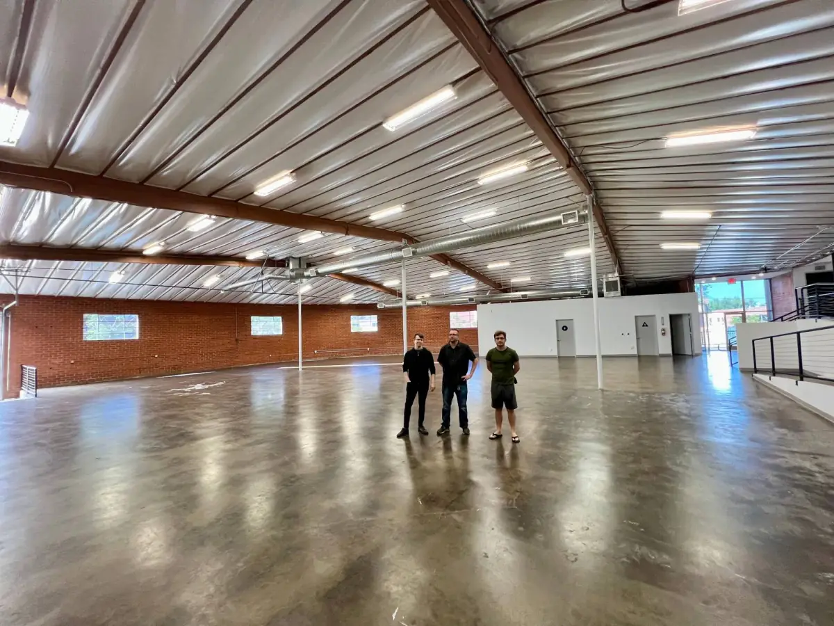 Three team members standing in the empty Los Angeles factory space in 2020